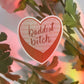 baddest bitch sticker, orange candy heart with words" baddest bitch" on the top and words: "of all time" in the background. cute candy hearts to reminder yourself that you're a baddie